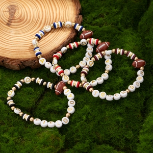 Set of four colorful football themed beaded bracelets with sports words on moss background