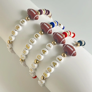 Detail of four handmade clay bead bracelets with football charms and sport letter beads