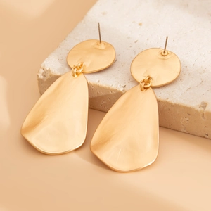 Detailed view of matte gold folded teardrop earrings with textured hammered finish