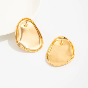 Detailed close-up of chunky gold liquid metal teardrop earrings with a polished surface