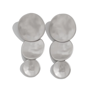 Detail of matte silver earrings with three tiered irregular hammered geometric disks