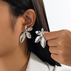Detail of silver leaf layered earrings with polished finish and organic artistic aesthetic