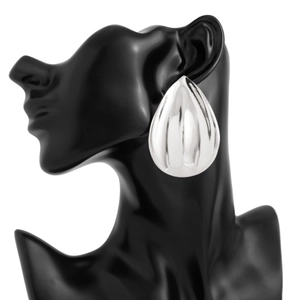 Detail of silver ribbed water drop earring on model showing metallic texture and shine