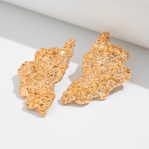 Detailed close-up of gold lava texture drop earrings with irregular hammered surface