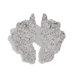 Close-up of irregular silver droplet earrings with a textured hammered finish and polished metal