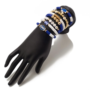 Detail of Gameday acrylic bead bracelet set with football charms on a display hand