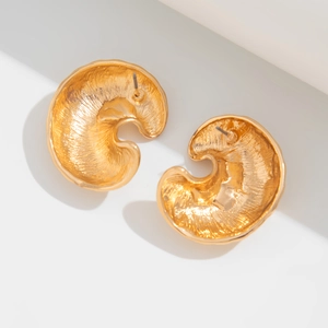 Detailed close-up of golden irregular waterdrop earrings with hammered metal texture