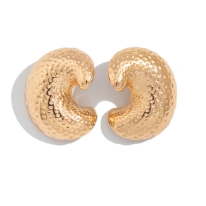 Detail view of gold earrings with hammered texture and fold water drop geometry