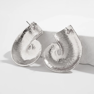 Dettaglio orecchini a spirale nautilus argento con texture radiale su pietra