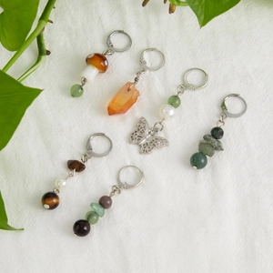 Detailed set of mushroom and crystal bohemian earrings on a white linen surface