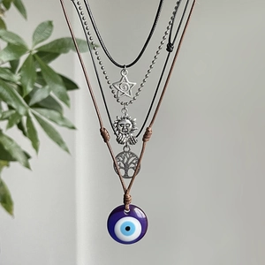 Λεπτομέρεια από boho κολιέ με μενταγιόν το μάτι του κακού, τον ήλιο και το δέντρο της ζωής