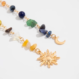 Detalle de cadena para el pelo boho con piedras naturales y colgantes de sol y luna
