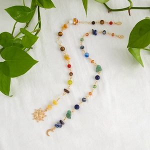 Detalle de cadenas para el pelo bohemias con cristales turquesas y colgantes de sol y luna