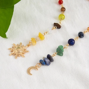 Detalle de cadena dorada para el pelo con piedras naturales y dijes de sol y luna