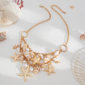 Detailed view of bohemian gold necklace with starfish pendants, shells and pearls
