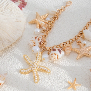 Detail of golden beach waist chain featuring faux pearls, starfish, and seashell pendants