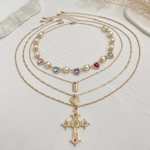 Platliggende vintage gelaagde kettingen met parels en grote kristallen kruis hanger