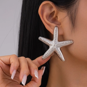 Close-up of a large silver starfish earring with textured finish on a female model