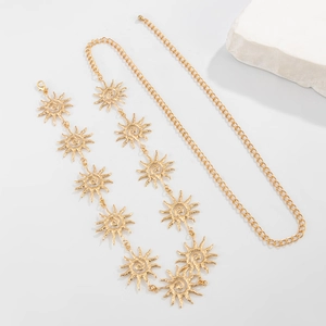 Détail de la chaîne de taille dorée avec pendentif soleil et texture spirale