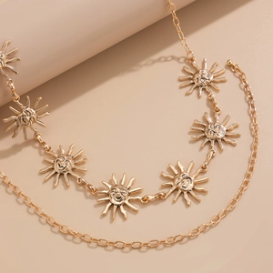 Détail de pendentifs soleil dorés avec sourires sur une chaîne de corps tendance