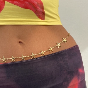 Detail of golden starfish chain belt worn on waist for beach vacation style