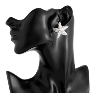 Detailed close-up of starfish stud earring with inlaid pearls on black model