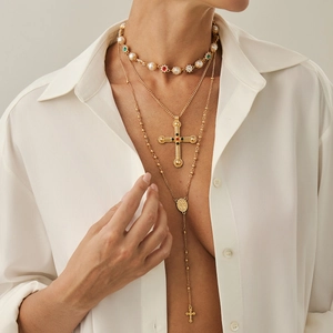 Detail van de gelaagde ketting met kruishanger, parels en gekleurde edelstenen