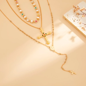 Detail van barokke goudkleurige gelaagde ketting met kruishangers en kleurrijke kralen