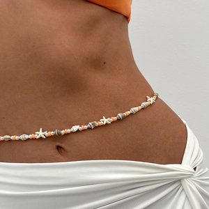 Détail d'une chaîne de corps de plage avec étoile de mer, coquillages, perles et argile