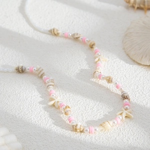 Détail de la chaîne de corps bikini d'été avec perles, coquillages et perles roses