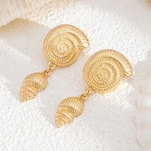 Detailed close-up of golden nautical drop earrings with shell and conch motifs