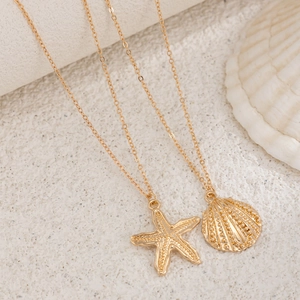 Close-up of golden beach body chain with detailed starfish and seashell pendants