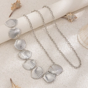 Detailed macro of silver starfish charms on a woven beach body chain for women