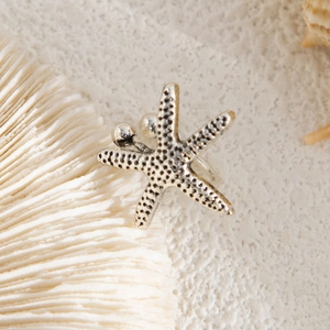 Detailed close-up of antique silver starfish earring featuring realistic dotted metal texture