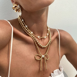 Bohemian multilayer gold bead necklace set with bow pendant and pearl accents