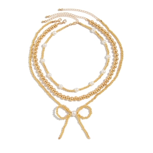 Three-layer gold beaded necklace set featuring a faux pearl bow pendant on a white background