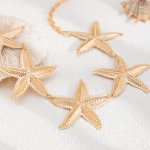 Bohemian gold starfish body chain with textured metal pendants for beach summer style