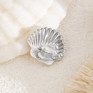 Macro view of silver seashell ear cuff featuring radiant textures and a secure U-clip closure