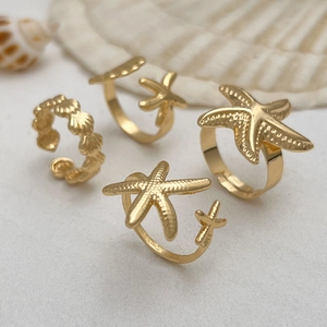 Gold ocean theme adjustable ring set with starfish and seashell charms on shells