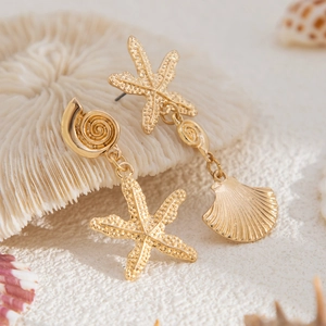 Golden asymmetric starfish and seashell drop earrings for a beach vacation style