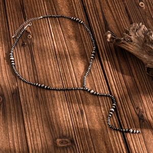 Detail of vintage Y-shaped beaded necklace with lobster clasp and extension chain