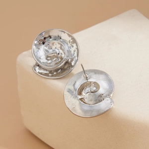 Close-up of silver starfish earrings with hand-hammered texture and spiral design