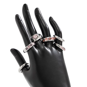 Detailweergave van zilveren ringen met roze en paarse edelstenen op een handmodel