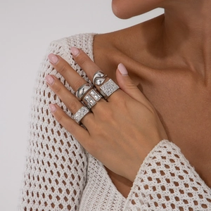 Detail of five-piece silver ring set with hollow cubic zirconia and textured bands