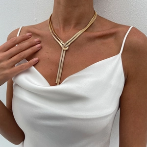 Close-up of golden layered snake chain necklace with an elegant knotted design on model