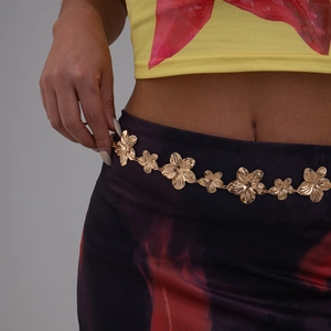 Détail de la chaîne de taille à fleurs en métal doré sur mannequin avec robe ethnique