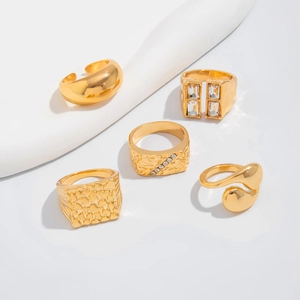 Detailed close-up of 5-piece gold-plated ring set with embossed textures and zircons
