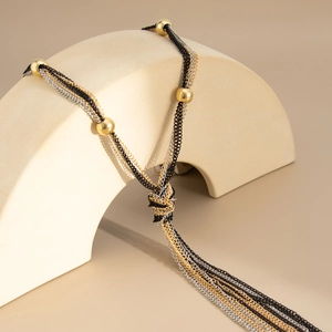 Detailed view of tricolor layered fringe necklace with metal chains and gold beads