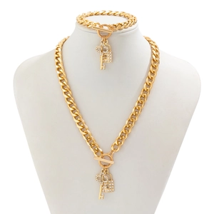 Detalle de conjunto de joyería de cadena dorada con dijes de llave y candado con cristales
