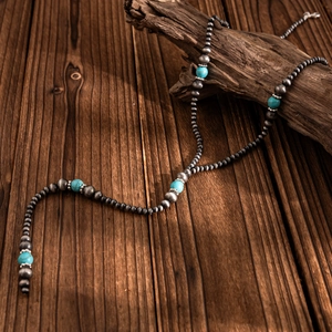 Detail of bohemian Y-shaped necklace with retro silver beads and turquoise stones